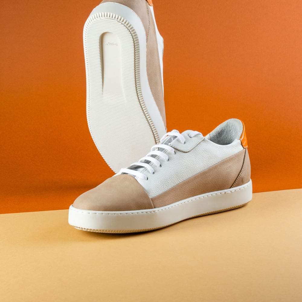 The sneakers against an orange background