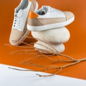 Another setting of sneakers against an orange background