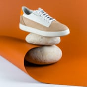 Another setting of sneakers against an orange background