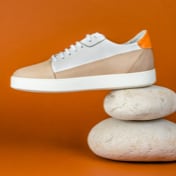 Another setting of sneakers against an orange background